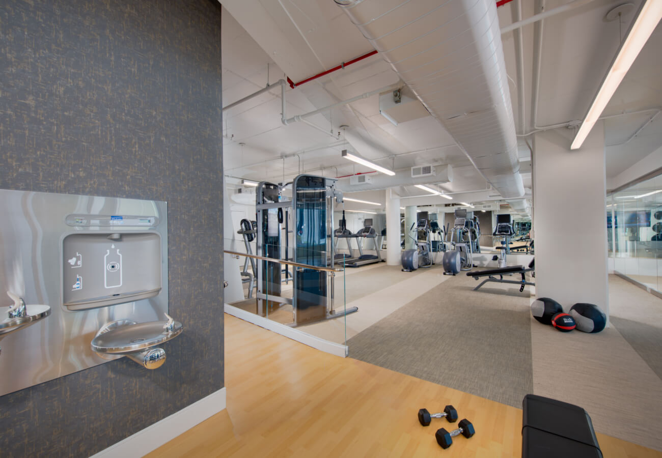 Fitness center at Fifty Three Thirty Three Apartments with cardio machines, strength equipment, and water station.