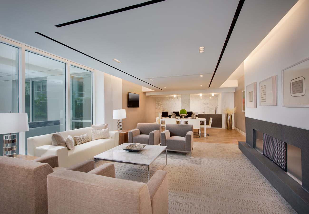 Clubroom at Fifty Three Thirty Three Apartments with sofas, fireplace, dining table, and kitchenette.